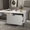 A white coffee table with an open drawer, a magazine, a mug, and a plant on it, next to a gray sofa. Voir les images du produit