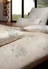 A close-up view of a bed with patterned bedding and pillows, with a window and a floor lamp in the background. Produktbild-Vorschau