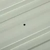 A close-up view of a light gray corrugated metal sheet with a small black hole in the center. Podgląd zdjęcia produktu