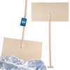 A wooden snow shovel is shown in front of a pile of snow, with a second shovel visible in the background. Náhled obrázku produktu