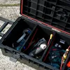 An open black tool box with various tools inside, placed on a concrete surface. Náhled obrázku produktu