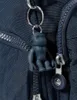 Close-up of a dark blue Kipling bag with a monkey charm and zipper. Produktbild-Vorschau