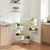 A white rolling cart with five tiers filled with various fruits and vegetables, placed in a kitchen setting next to wooden cabinets. Voir les images du produit
