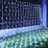 A net of white LED lights draped over a metal fence and onto the grass. Produktbild-Vorschau