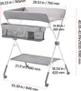 A gray foldable changing table with storage compartments and a shelf, shown from a front-diagonal angle with dimensions overlaid. Voir les images du produit