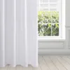 A white curtain hangs in front of a window with green foliage visible outside. The floor is made of light-colored wooden planks. Produktbild-Vorschau