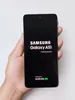 A hand holding a Samsung Galaxy A51 smartphone displaying the boot-up screen. Náhled obrázku produktu