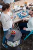 A couple enjoying drinks and snacks outdoors at a table with a cooler. Podgląd zdjęcia produktu