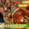 A girl and a woman are looking at a wooden chicken coop with chickens inside. There are overlays and text on the image. Produktbild-Vorschau