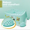 A mint green plastic step stool with farm animal illustrations, featuring a magnified view of its non-slip base. Text indicates it's robust, stable, and has an anti-slip function. Produktbild-Vorschau