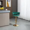 A green velvet bar stool with a gold base is shown in a kitchen or dining area. Voir les images du produit