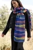 A woman wearing a black jacket and a colorful scarf stands outdoors. Produktbild-Vorschau
