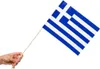A hand holding a small flag of Greece on a white background. Produktbild-Vorschau