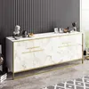A white sideboard with a marble-like finish and gold accents, set against a black and white striped wall. Náhled obrázku produktu