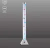 A tall, clear bubble lamp with colorful fish inside, standing on a white triangular base. Produktbild-Vorschau
