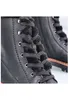 A close-up view of the lacing and fur lining of a black boot. Voir les images du produit