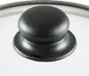 A close-up view of a black knob on a glass lid. Voir les images du produit