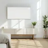 A modern living room with a white entertainment center, a white infrared heater mounted on the wall, and a potted plant. Náhľad obrázku produktu