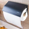 A black paper towel holder mounted on a tiled wall, with a roll of white paper towels dispensed. Produktbild-Vorschau