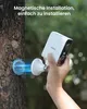 A hand is holding a white security camera near a tree, demonstrating magnetic installation. Náhled obrázku produktu