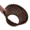 A hand holding a brown wicker basket against a white background. Produktbild-Vorschau