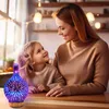 A woman and a child are looking at each other and smiling, with a decorative aroma diffuser in the foreground. Voir les images du produit