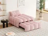 A pink puffy sofa bed with an extended footrest is shown in a well-lit room with a plant and shelves in the background. Produktbild-Vorschau