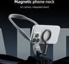 A magnetic phone neck holder is displayed on a dark, textured surface, with a dark background. The product is shown attached to a smartphone. Produktbild-Vorschau