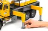 A hand is shown adjusting the support leg of a toy crane truck. Náhľad obrázku produktu