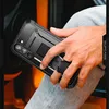 A person's hand holding a black phone case with a built-in stand and ring. Produktbild-Vorschau