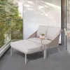 A modern outdoor lounge chair with a chaise extension sits on a tiled balcony, with greenery visible through a glass railing. Náhled obrázku produktu