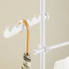 A close-up of a white telescopic clothes rack with an umbrella hanging from it. Produktbild-Vorschau