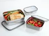 Three stainless steel lunchboxes with clear lids, two filled with food, on a white background. Produktbild-Vorschau
