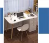 A modern white desk with wooden legs, a white chair, and various office supplies is set up in a room with sheer curtains. Produktbild-Vorschau