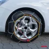 A close-up of a car tire with snow chains installed, resting on a paved surface. Produktbild-Vorschau