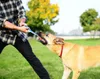A person playing tug-of-war with a dog in a park. Produktbild-Vorschau