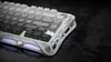 A close-up shot of a white mechanical gaming keyboard with a unique, sculpted frame and RGB lighting. Produktbild-Vorschau