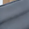 A close-up view of the textured fabric of a dark gray sofa cushion. Náhled obrázku produktu