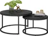 Two nesting round coffee tables with black marble-effect tops and black metal bases, decorated with a plant and books. Voir les images du produit