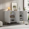 A white sideboard with gold legs and handles, decorated with items on top and inside its open doors. Voir les images du produit