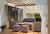 A polyrattan lounge set on a wooden deck under a pergola with string lights. Produktbild-Vorschau