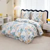 A neatly made bed with floral patterned bedding in a bedroom setting. Náhľad obrázku produktu