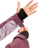 A person is adjusting the velcro closure on the sleeve of a purple jacket. Produktbild-Vorschau