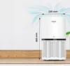 A white air purifier with dimensions indicated, placed on a wooden surface against a white and light gray background with abstract blue air flow graphics. Produktbild-Vorschau
