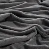 A close-up view of a folded, dark gray blanket. Produktbild-Vorschau