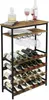 A wine rack filled with wine bottles and wine glasses, with a decanter and books on the top shelf. Podgląd zdjęcia produktu
