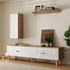 A modern living room setup featuring a wall-mounted cabinet and a long media console with carved doors, all in white and wood tones. Produktbild-Vorschau