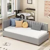 A gray daybed with several decorative pillows is placed in a well-lit room with a window, a dining table, and chairs in the background. Produktbild-Vorschau