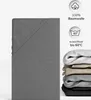 A folded grey fitted sheet is shown on the left, with product information icons and text on the right. A stack of folded sheets in various colors is shown at the bottom right. Produktbild-Vorschau