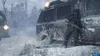 Two figures in tactical gear stand next to a weathered vehicle in a snowy environment. Produktbild-Vorschau